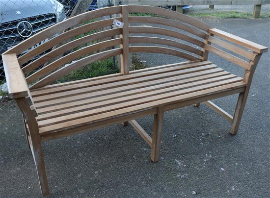 A modern teak bow back garden bench,